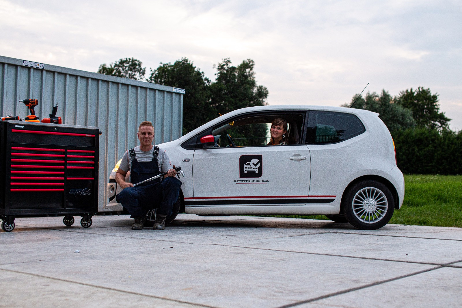 Janno de Heus met een momentsleutel naast de VW up! met het logo van het bedrijf