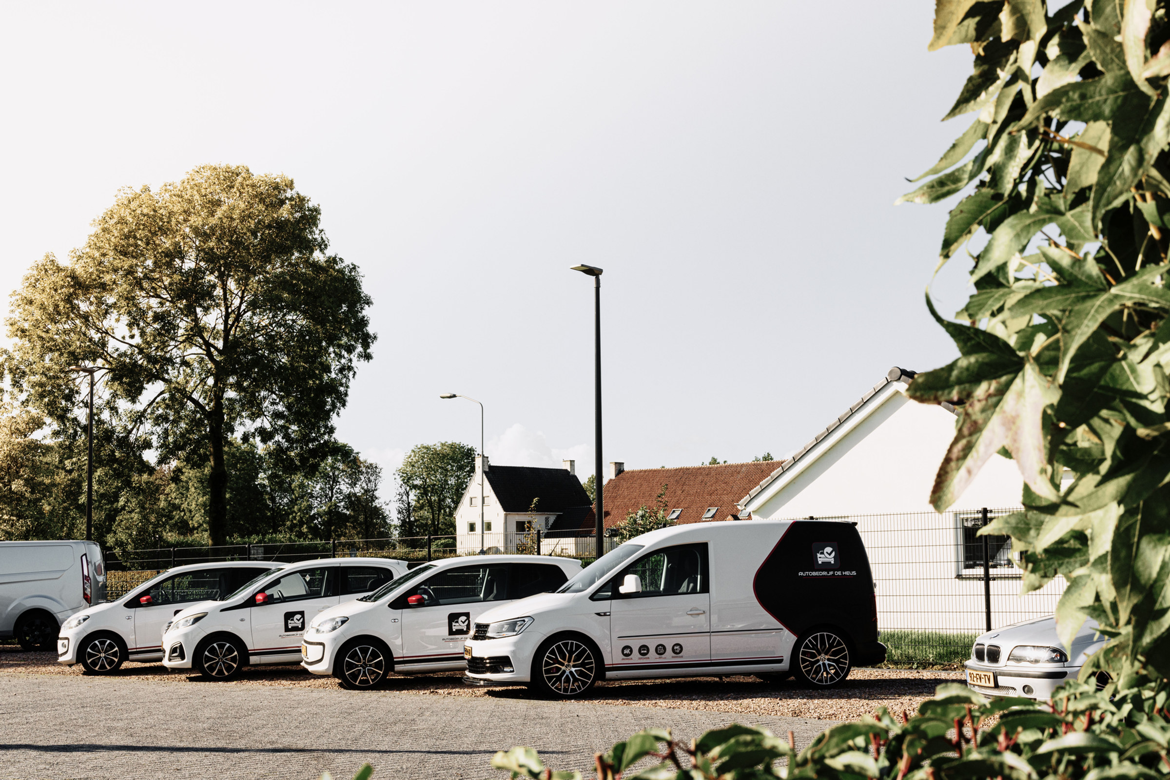 Witte VW up's en een Caddy met het logo van De Heus op het terrein